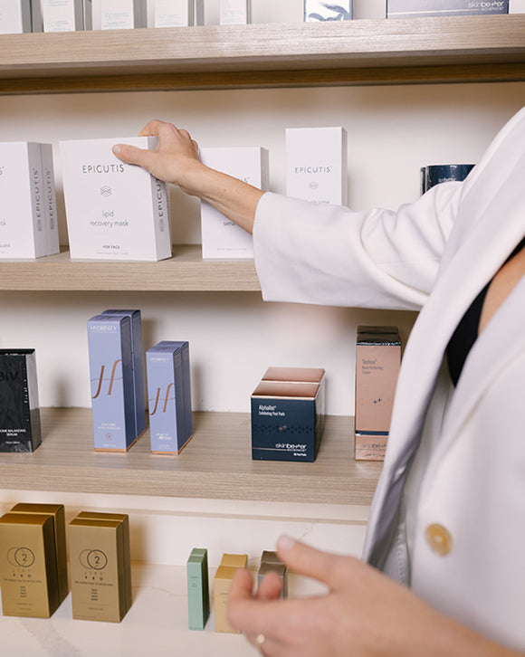 Hand reaching for skin care product on shelf
